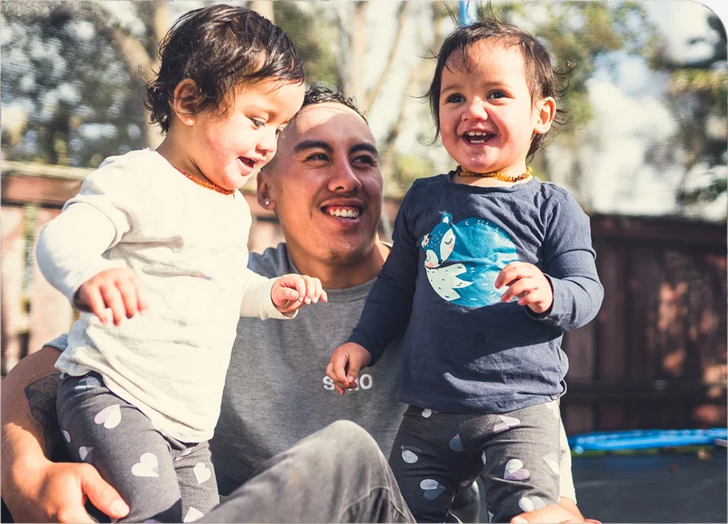 Man smiling with his 2 children